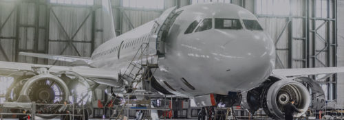 White plane being worked on in a facility